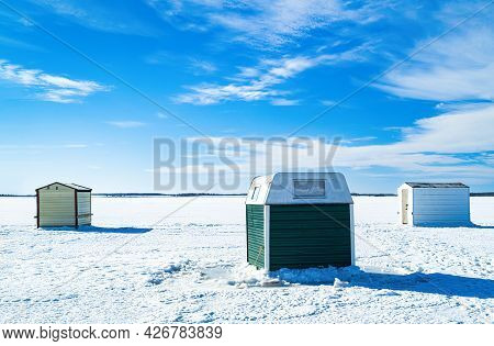 Ice Fishing On A Frozen Harbor Along The Coast Of Prince Edward Island, Canada.