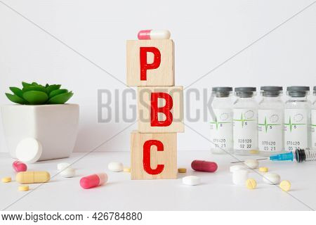 The Word Pbc Is Written On Wooden Cubes Near A Stethoscope On A Wooden Background. Medical Concept,