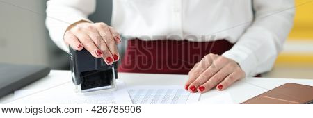 Businesswoman Puts Stamp On Documents On Work Table