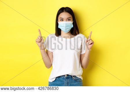 Covid-19, Pandemic And Social Distancing Concept. Young Asian Woman In White T-shirt And Medical Mas