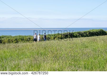 Old Hunstanton, Norfolk, England - June 13, 2021. Three People On Their Back Walking Near Old Hunsta