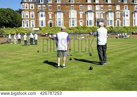 Old Hunstanton, Norfolk, England - June 13, 2021. Two Men On Their Back Playing The Lawn Bowls.