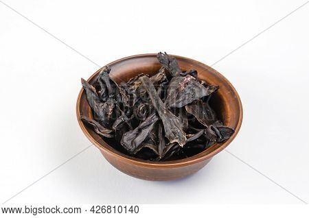 Dried Dog Treats In A Brown Clay Bowl On A White Background. Thin Slices Of Dehydrated Beef Kidneys.