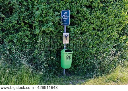 Elgg, Switzerland June 17, 2021: Nature Protection Area, Green Waste Bucket With Dog Waste Bag And N