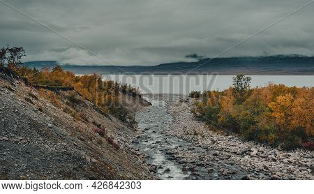 A Mountain River Flows Into A Tornetrask Lake In The Foggy Abisko National Park In Polar Sweden In T