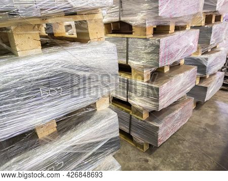 Abstract Industrial Palleted Production Stacks Indoors On The Floor With Handwritten Markings 502