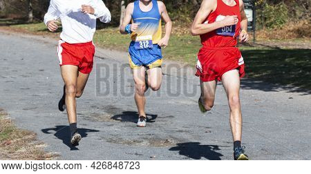 Thre High School Boys Competing In A Cross Country Running Race On A Gravel Path At Van Cortlandt Pa