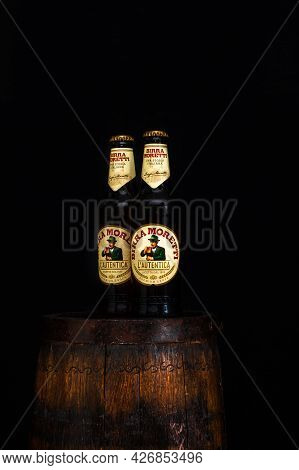 Bottle Of Birra Moretti Beer On Wooden Barrel With Dark Background. Illustrative Editorial Photo Buc