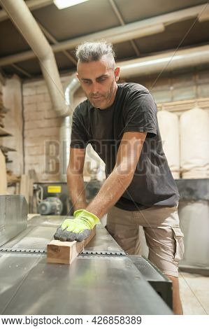 Carpenter Processes Wood In A Furniture Workshop