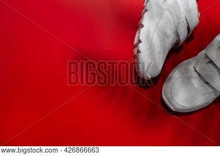 Flat Lay Two White Kid Sneakers With Hard Shadows From The Leaves Of A Palm Tree Or A Fern Monstera 