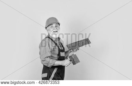 Plaster Trowel Spatula On Yellow Drywall Plasterboard. Plasterer In Working Uniform Plastering. Man 