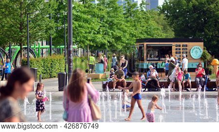 15 July 2021. Warsaw, Poland. Children In Bathing Suit Playing In The Splash Pad Water Fountain In T