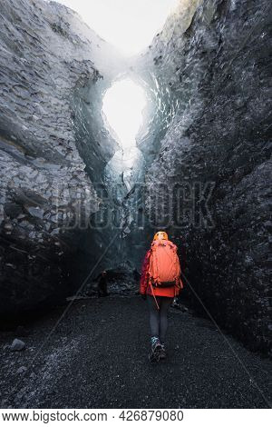 Female explorer walking to the ice cave, Iceland