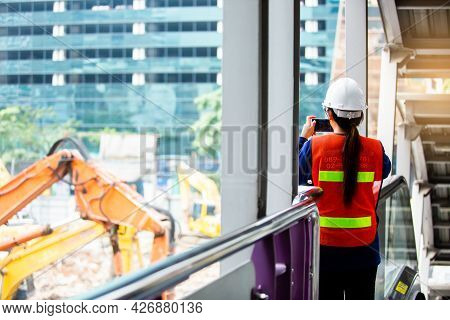 The Woman Foreman Is Standing To Monitor And Take Photo With Smartphone To Control The Demolition Of