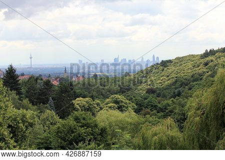 The Skyline Of Frankfurt, Hessen, Germany Behind A Small Forest