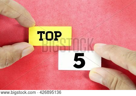 Hand Holding A Wooden Cube With The Word Top 5
