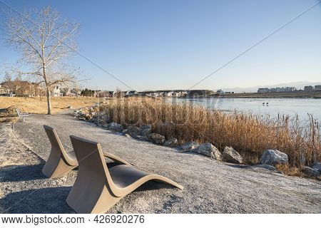Two Lounge Chairs Along The Trail At The Side Of The Lake Waterfront