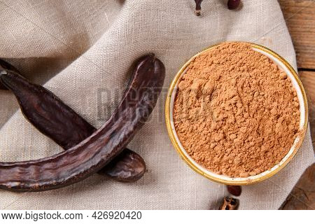 Dry Carob Pods And Carob Powder On Linen Napkin