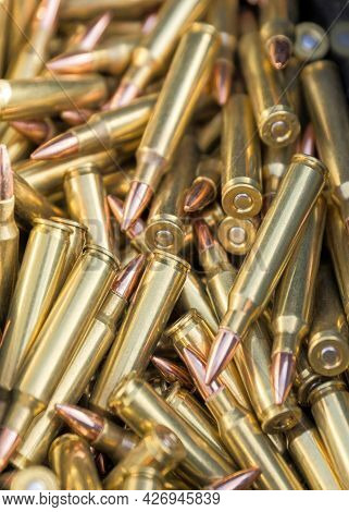 Vertical Loads Of Long Sharp Bullets Inside Its Case With A Blue Cloth On The Side.