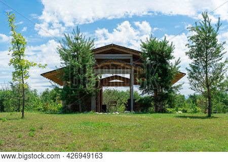 Beautiful Wooden Gazebo In A Green Clearing With Trees. A Place To Relax In Nature