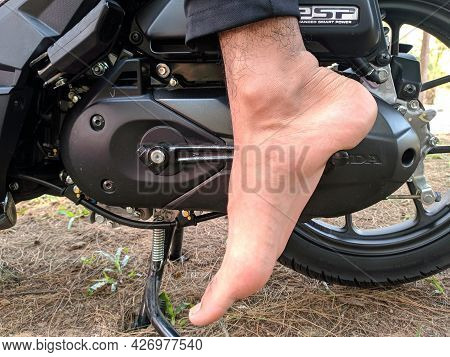 Malaysia, Kuala Terenganu 17 July 2021 : Feet Are Kicking The Motorcycle Starter