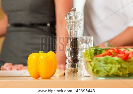 Mand og kvinde i køkkenet - de forberede grøntsager og salat til aftensmad eller frokost