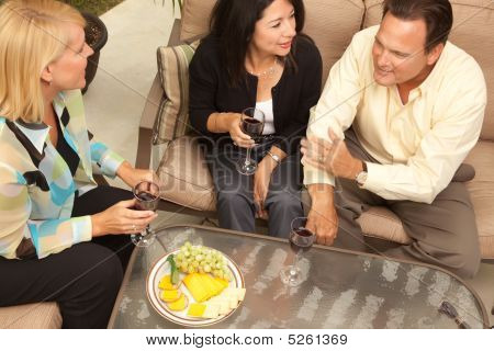 Tre amici, godendo di vino sulla terrazza