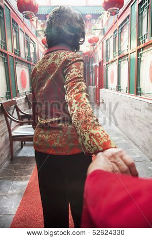 Rear view of senior couple holding hands