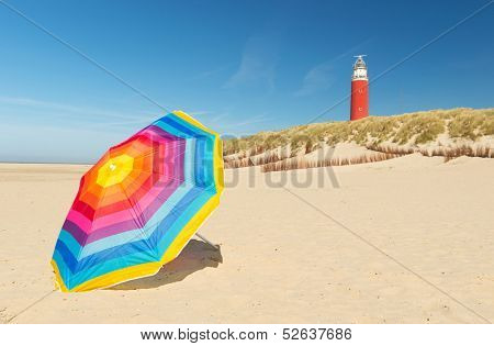 lighthouse with colorful parasol in front on Dutch wadden island Texel
