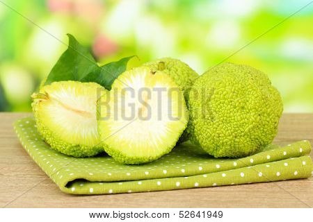 Osage Orange fruits (Maclura pomifera), on wooden table, on nature background