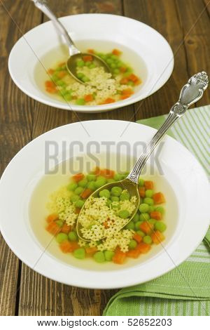 Soup With Star Shaped Noodles, Carrots And Green Peas