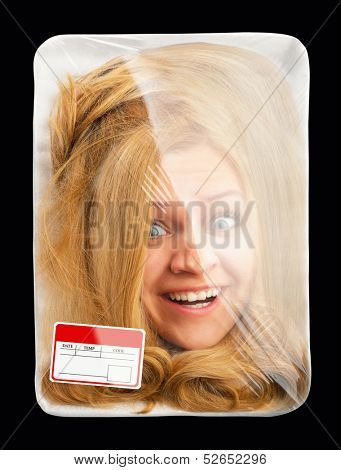 Surprised female head wrapped in food tray. Isolated on black