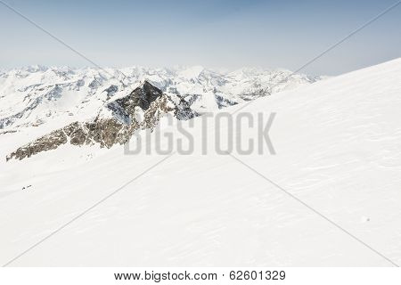 Snow Covered Slope With Mountain Ridge In The Back