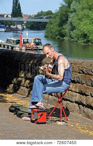 Guitarist busking on riverbank, Chester.