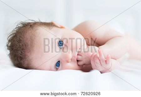Close Up Portrait Of A Cute Baby Girl With Big Beautiful Blue Eyes Sucking On Her Fingers