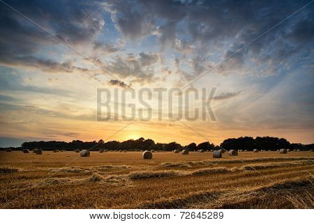 Rural Landscape Image Of Summer Sunset Over Field Of Hay Bales