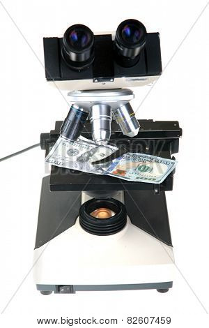 a one hundred dollar bill set up for examination under a microscope to view if it is counterfeit or legitimate. isolated on white with room for your text