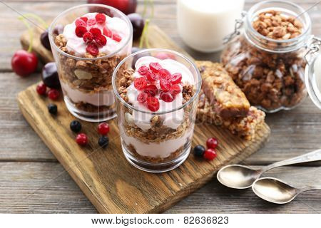 Healthy layered dessert with muesli and berries on table