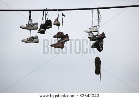 PRAGUE, CZECH REPUBLIC - APRIL 6, 2013: Old boots hang on an electrical cable in Letna, Prague, Czech Republic. According to legend, teenagers throw shoes on the cable, when they lose their virginity.