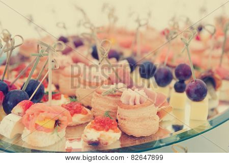 Meat, fish and cheese banquet snacks on banquet platter, toned image