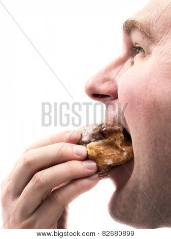 Side shot of man eating donut shot on white                            