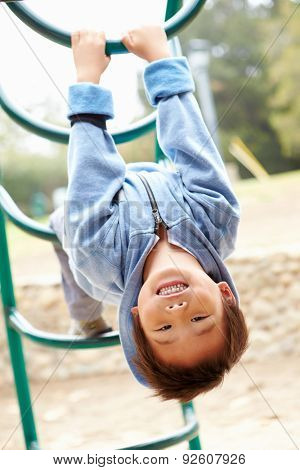 Young Boy On Climbing Frame In Playground
