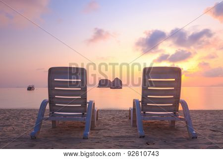 Beach chairs on the evening sea coast