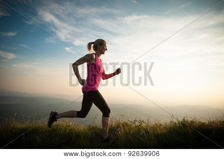Beautiful Young Woman Runns Cross Country On A Mountian Path At Sunrise