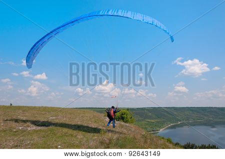 Paraglider Prepares To Fly Over Beautiful Bakota Reservoir.