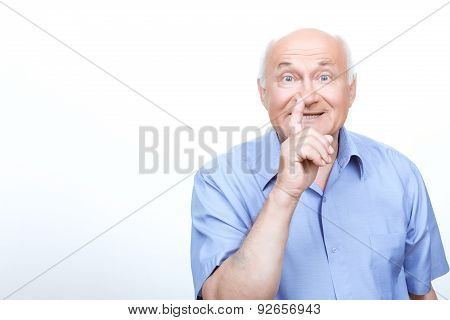 Old man holding finger in front of the mouth