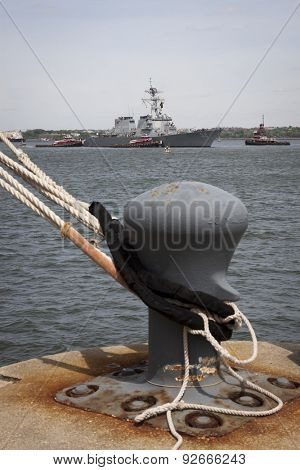 STATEN ISLAND, NY - MAY 20, 2015: USS Barry (DDG 52) is guided into port by McAllister tugboats at Sullivans Pier in Staten Island after the Parade of Ships that starts Fleet Week.
