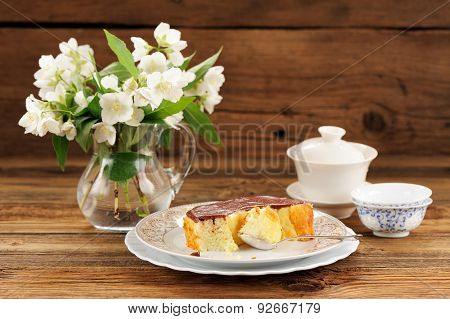 Homemade Baked Pudding With Chololate Icing, Jasmine Flowers In Glass Jar And Chinese Teaware On Woo