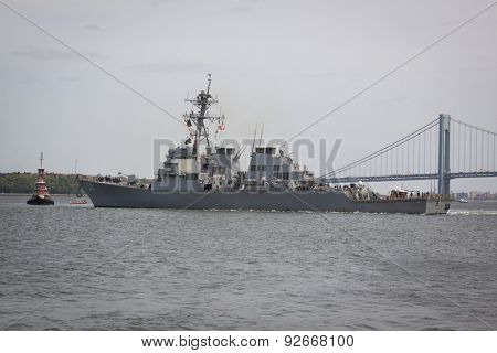 STATEN ISLAND, NY - MAY 20, 2015: USS Barry (DDG 52) is guided into port near the Verrazano-Narrows Bridge by McAllister tugboats at Sullivans Pier after the Parade of Ships that starts Fleet Week.
