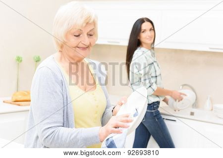 Granddaughter and grandmother washing up